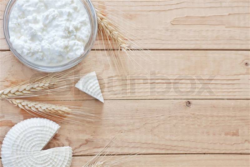 Tzfat cheese and cottage cheese with wheat grains. Symbols of judaic holiday Shavuot. Copy space background, stock photo