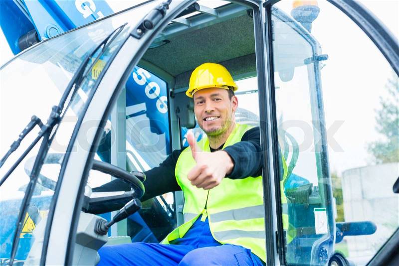 Builder or driver driving excavator on construction or building site, stock photo