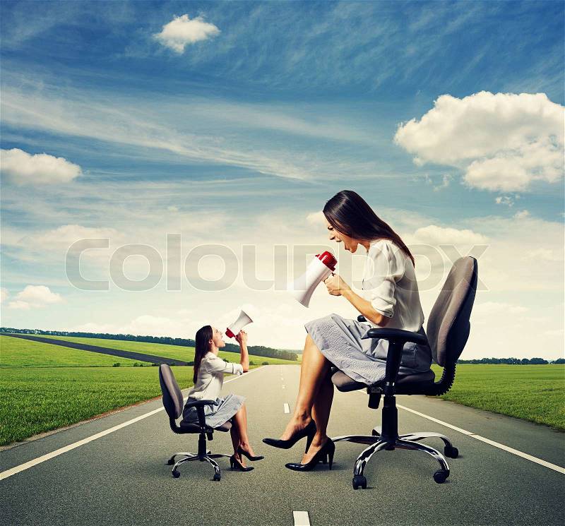 Small woman screaming at big displeased woman on the road, stock photo