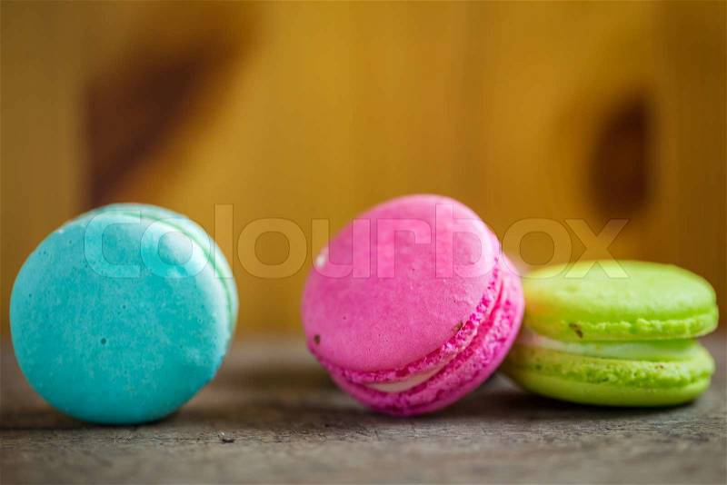 Colorful macaroons, delicious French pastries, on table, stock photo