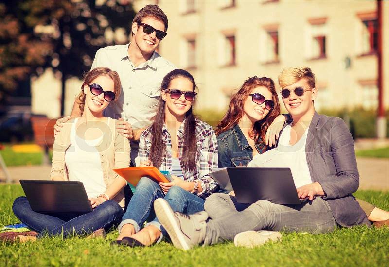 Summer, internet, education, campus and teenage concept - group of students or teenagers with laptop, notebooks, files and folders, stock photo