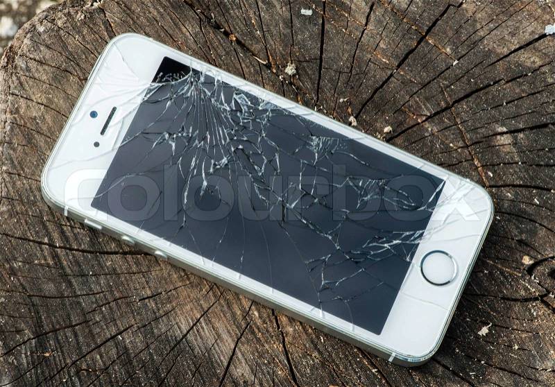 Broken white iphone glass on wood, stock photo