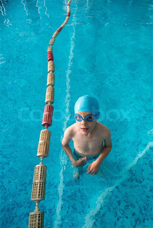 Little boy in swimming pool. Blue swimming pool, stock photo