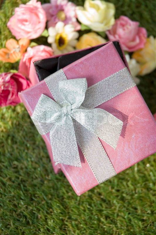 Sweet pink gift box on grass, stock photo