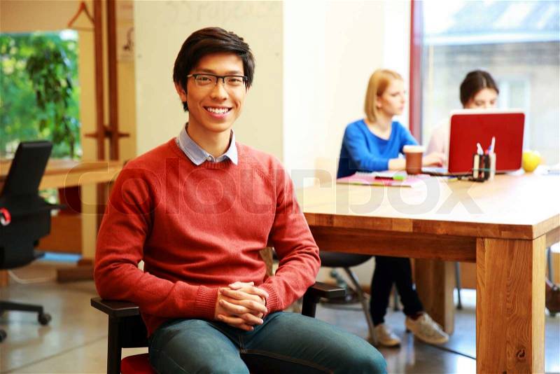 Smiling young asian student in classroom, stock photo