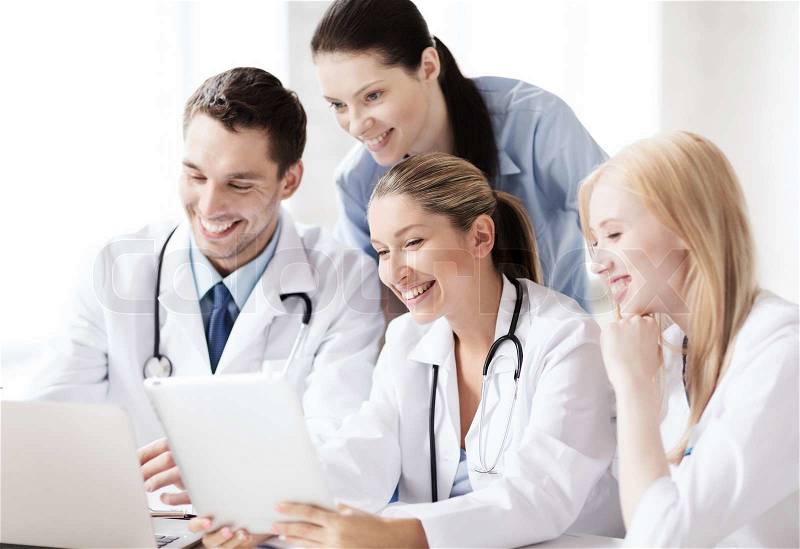 Healthcare, medical and technology concept - group of doctors looking at tablet pc, stock photo